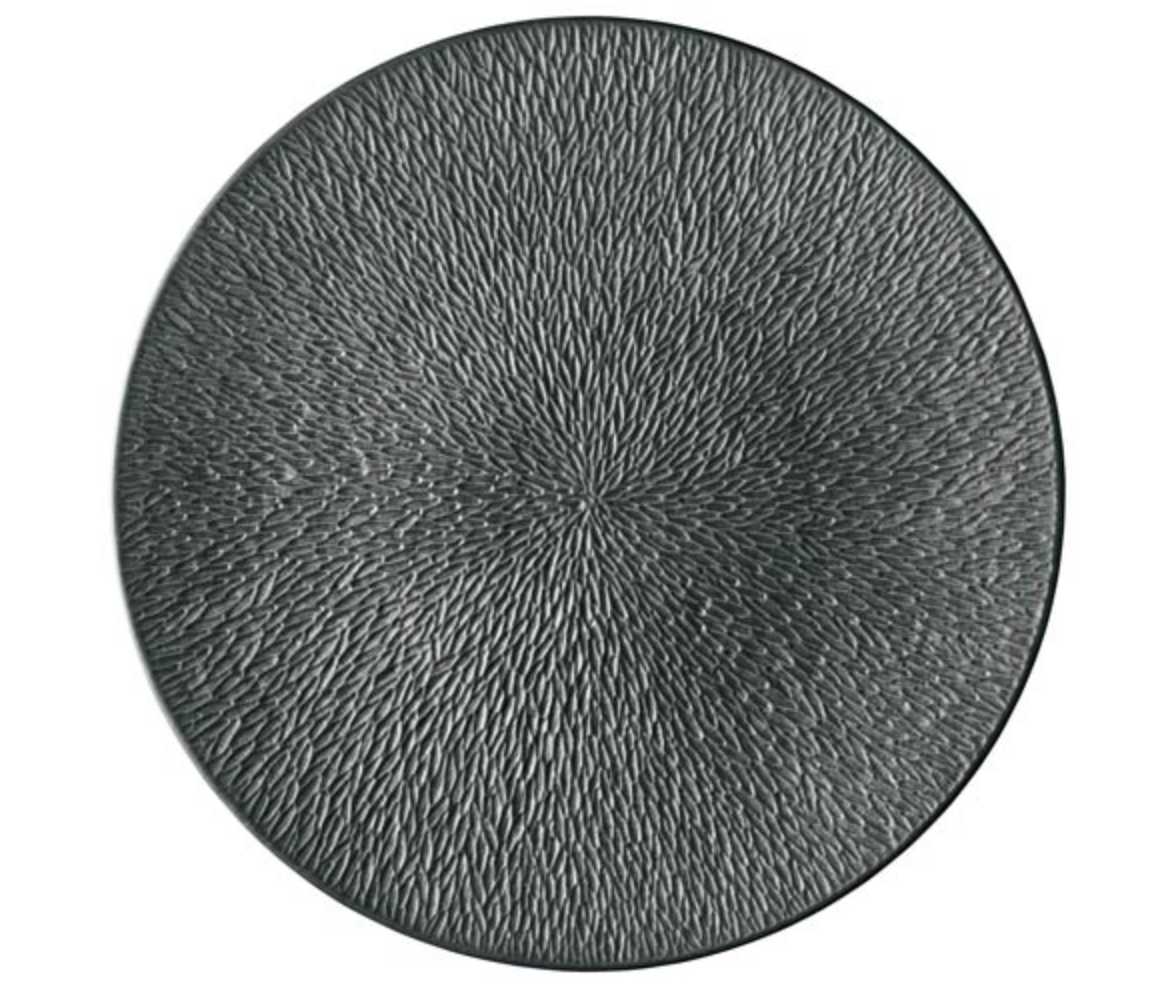The Raynaud Mineral Irise Dinnerware in Black features a round plate with a textured, radiating pattern—small raised lines fanning out from the center—for a modern and elegant touch to any table.