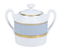 The Recamier Grey & Gold sugar bowl by Royal Limoges is crafted in France from white porcelain, featuring two handles, a lid, and an elegant gold-accented blue band around the middle.