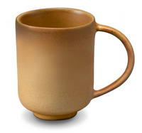 The L'Objet Terra Leather Dinnerware ceramic mug features a matte, speckled light brown finish and large rounded handle, recalling hand-crafted style, shown on a white background.