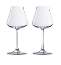 Two Baccarat Chateau Barware crystal wine glasses with wide bowls and slender stems are placed side by side against a white background, showcasing French elegance and craftsmanship.