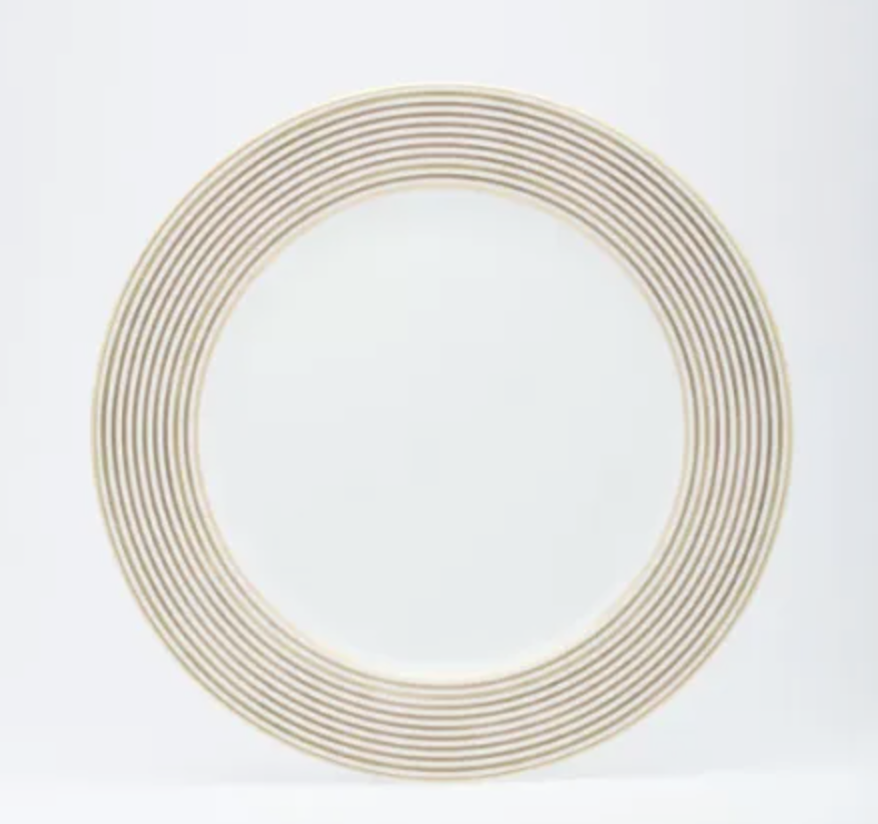 The Latitudes Dinnerware by Royal Limoges is a round white porcelain plate with fine gold stripes forming concentric circles on the rim, set against a plain white background.