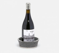 A wine bottle with a white label stands upright in the Angelica Grey Shagreen Wine Coaster by Blue Pheasant, featuring black and silver textured detailing, set against a plain white background.