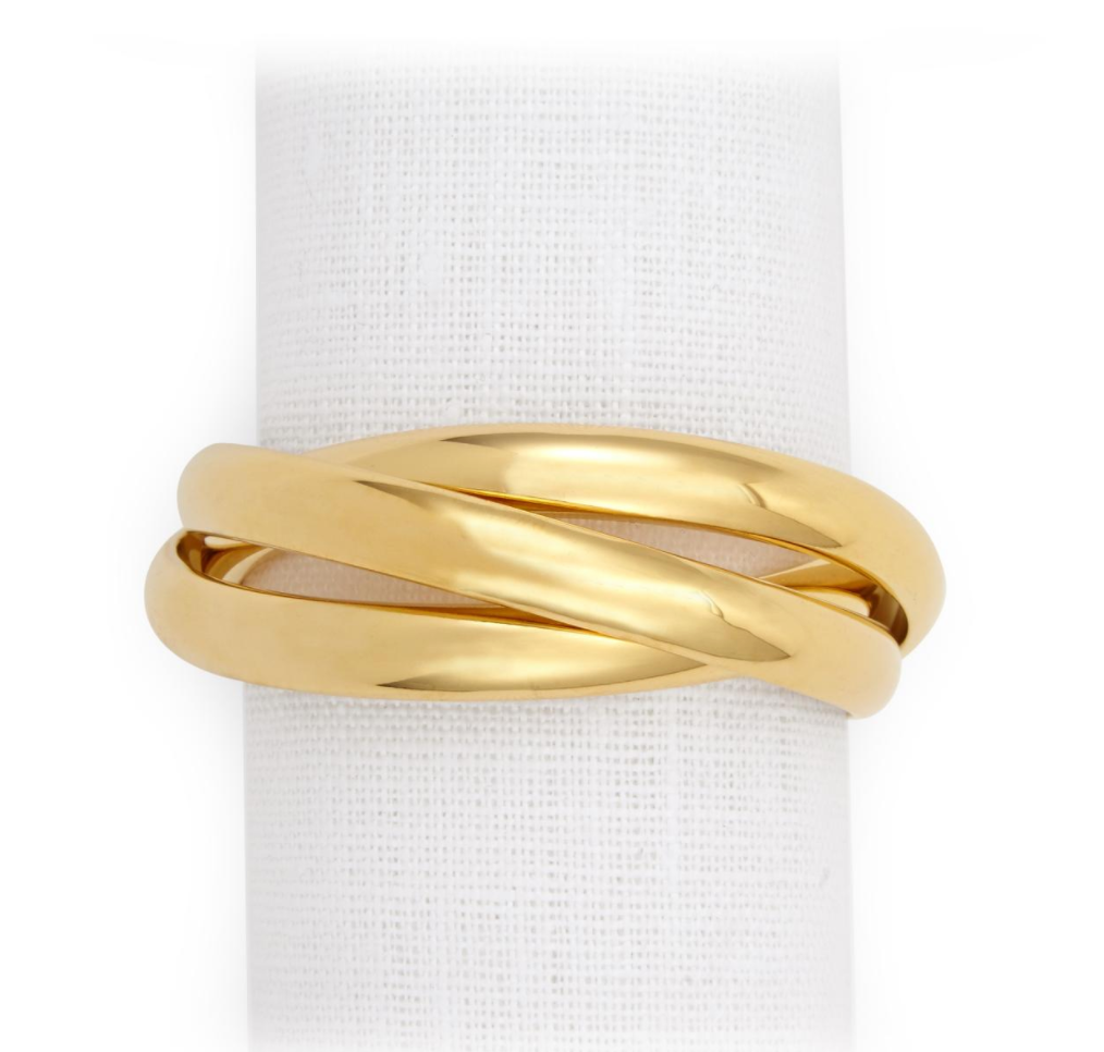 The Three Ring Jewel Napkin Set of 4 by L'Objet features three interlocking, polished 24k gold-plated bands, beautifully displayed on a white textured fabric background.