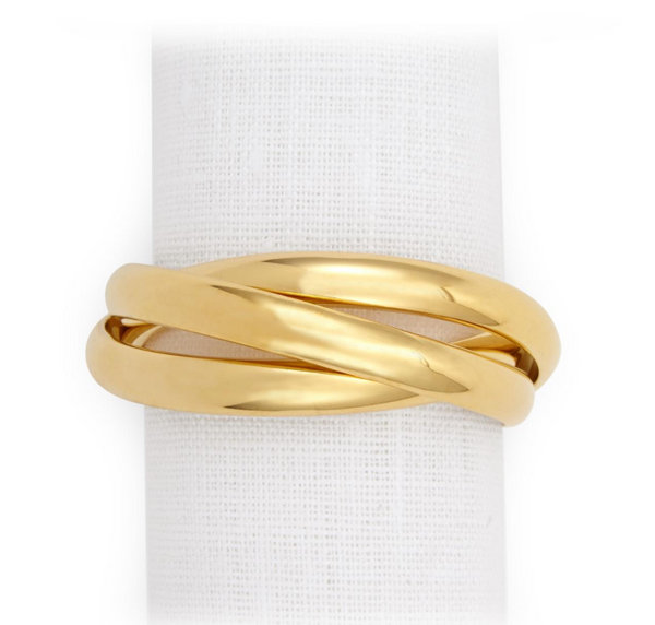 The Three Ring Jewel Napkin Set of 4 by L'Objet features three interlocking, polished 24k gold-plated bands, beautifully displayed on a white textured fabric background.