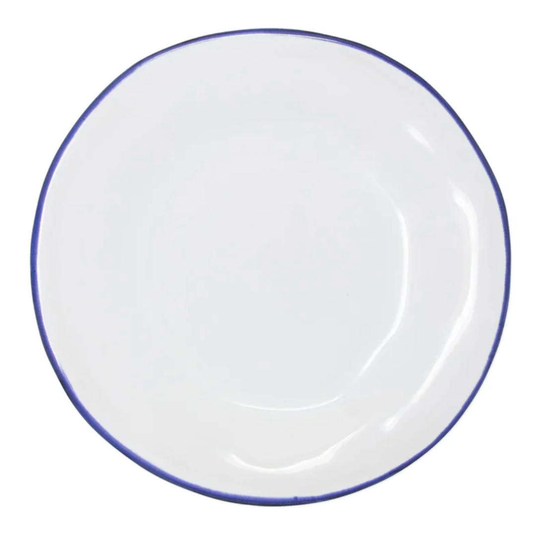 The Vietri Aurora Edge Dinnerware is a round, white ceramic plate with a thin, slightly uneven blue rim, handmade in Italy and shown from above on a plain white background.