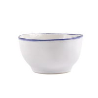 The Vietri Aurora Edge Dinnerware bowl is handmade in Italy from white stoneware with a subtle blue rim and is chip resistant, shown against a plain white background.