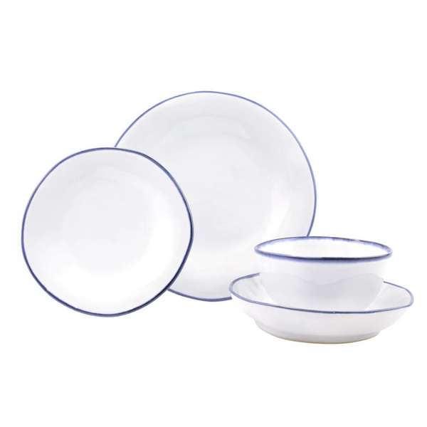 The Vietri Aurora Edge Dinnerware set features white stoneware with a thin blue rim, including two plates, a bowl, and a small dish—each chip-resistant and shown neatly arranged against a white background.