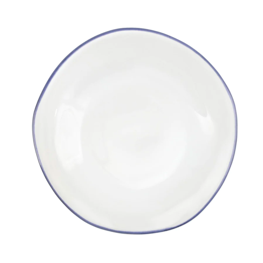 The Aurora Edge Dinnerware by Vietri is a round, white ceramic plate with a thin light blue rim and slightly irregular shape, handmade in Italy and shown from above on a white background.