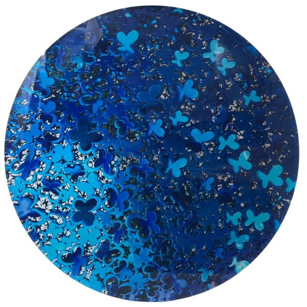 A circular image showcases shiny, metallic blue four-leaf clover shapes on a dark blue background, echoing the elegant patterns of the Eye Candy Blue Butterflies Lazy Susan.