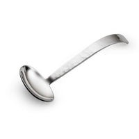 The Mary Jurek Valencia Gravy Ladle is handmade from stainless steel and features a deep, round bowl with a long, gently curved handle. Photographed on a white background.