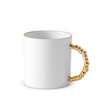 The L'Objet Haas Mojave Dinnerware Gold mug features fine white porcelain, a shiny gold beaded handle, and a thin gold rim, reflecting the signature elegance of the Haas Brothers collection.