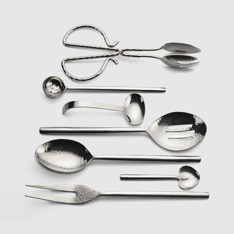 The Mary Jurek Versa Meat Serving Fork features a shiny, silver hammered design, perfect for stylish serving; it's part of the elegant Versa collection of specialized serving utensils.