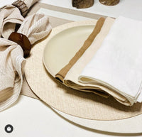 Create a stylish outdoor table with Bodrum’s Wicker Round Placemat Cream Set of 4, paired with a round beige plate and layered tan and white napkins, finished with a cream napkin and wooden ring for a chic, neutral-toned look.