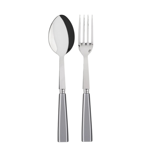 A Sabre Icone Serving Set, featuring a shiny metal spoon and four-pronged fork with matching silver handles, is displayed side by side on a white background.