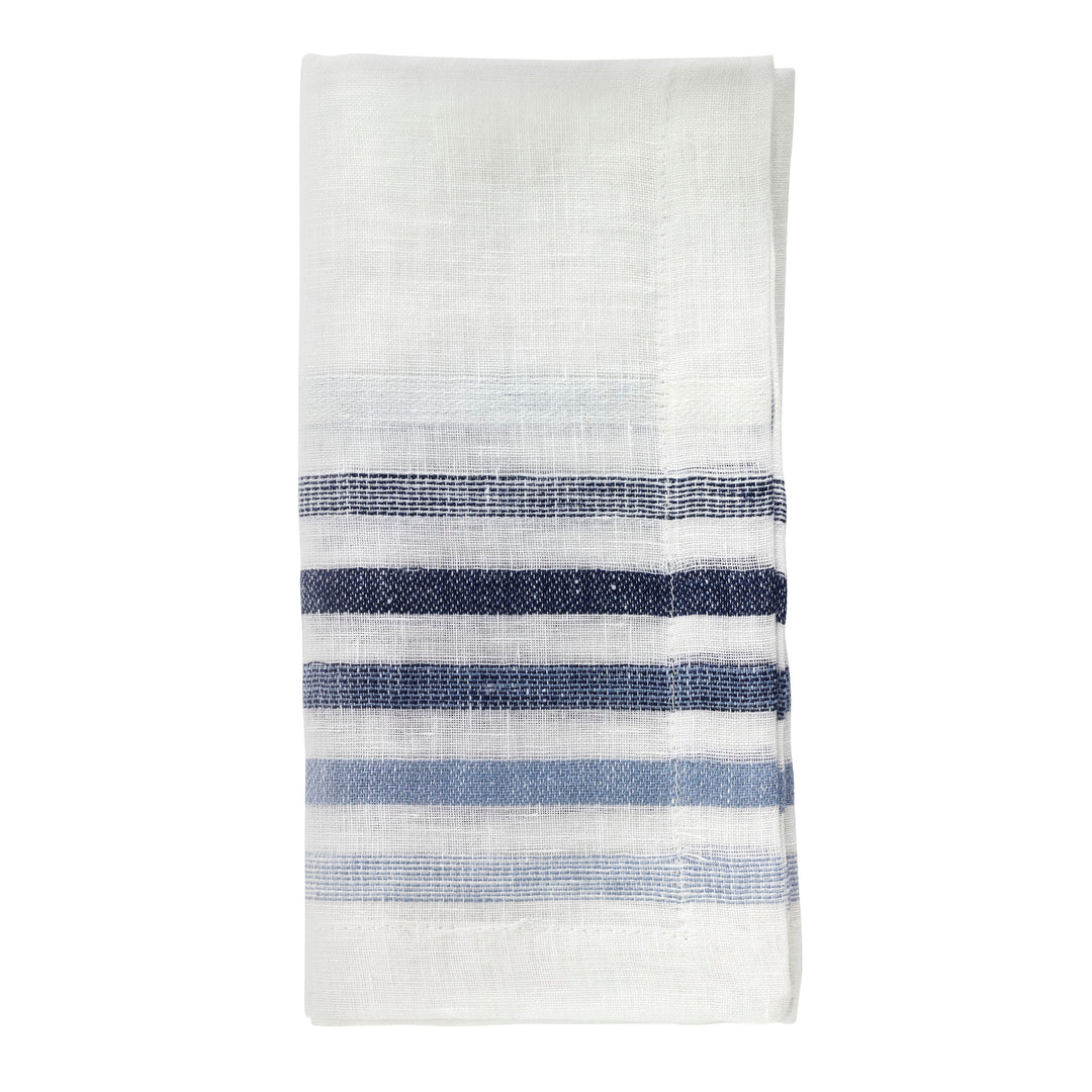 The Bodrum Logan Napkin Blue Set of 4 features elegant white napkins, each folded to display multiple horizontal blue stripes in varying shades near one end.