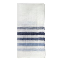 The Bodrum Logan Napkin Blue Set of 4 features elegant white napkins, each folded to display multiple horizontal blue stripes in varying shades near one end.