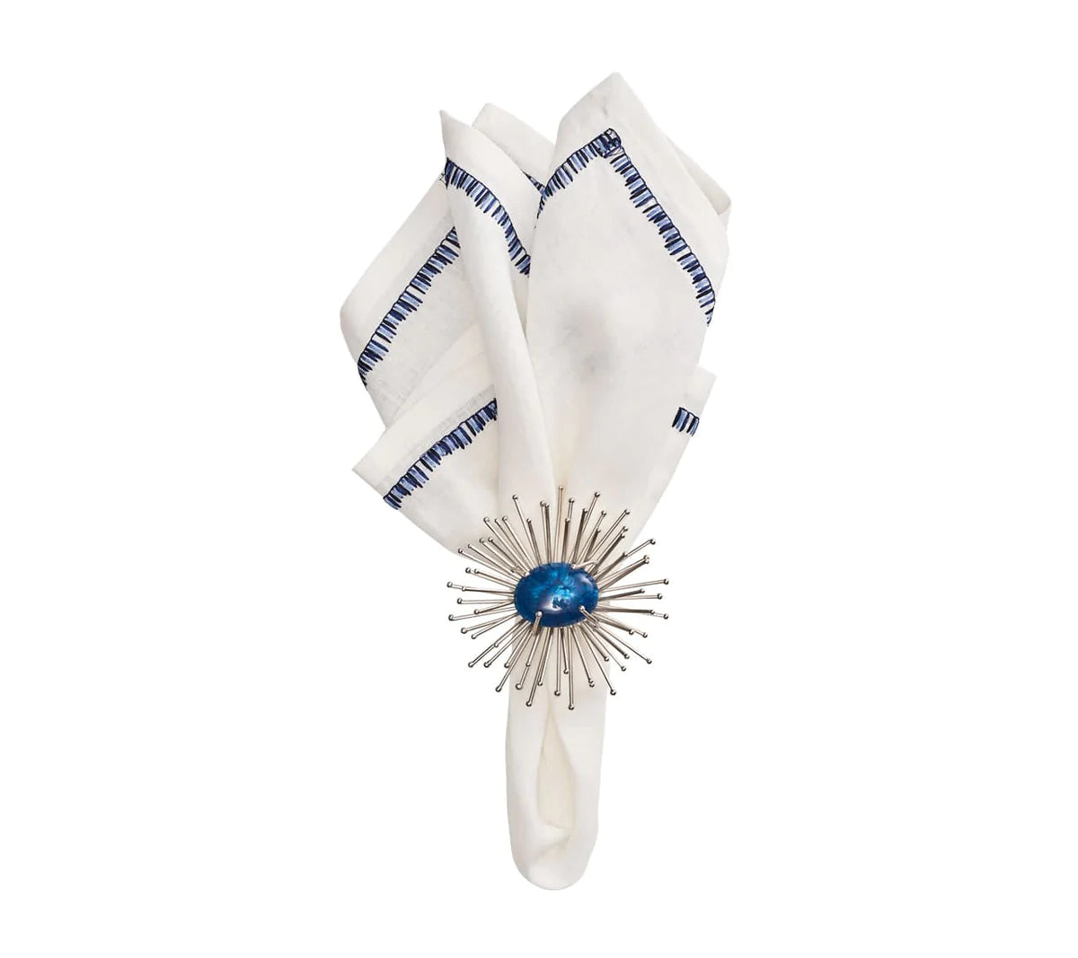 The Kim Seybert Filament Napkin White & Navy Set of 4 features white linen napkins with navy stitched edges, elegantly folded and secured by a round silver sunburst napkin ring with a glossy blue center.