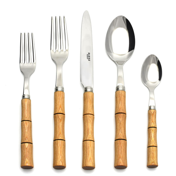 The Sabre Bamboo Flatware 5 Piece Setting features shiny 18/10 stainless steel tops and bamboo-style wooden handles, including a dinner fork, salad fork, knife, soup spoon, and teaspoon, arranged on a white background.