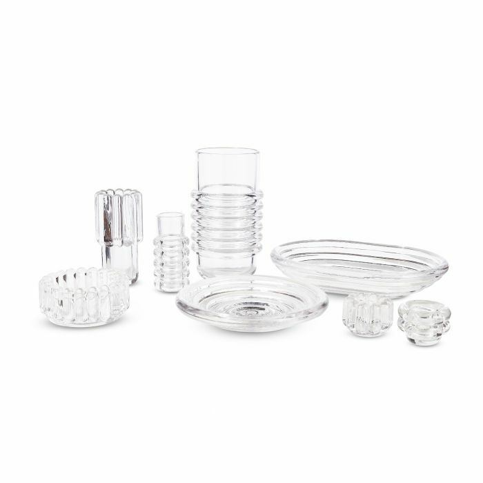 A set of clear ribbed glass tableware—plates, bowls, cups—and the Tom Dixon Press Vertical Tealight are arranged together on a white background.