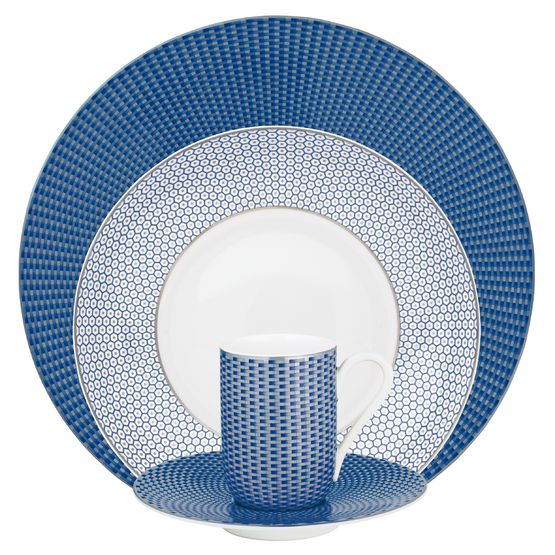 The Raynaud Tresor Dinnerware Blue set includes four elegant porcelain pieces—a dinner plate, salad plate, cup, and saucer—adorned with blue and white geometric patterns for a refined dining experience.