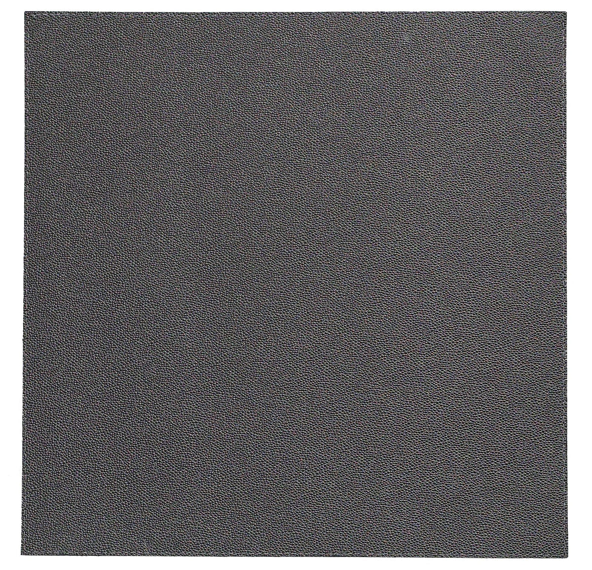A close-up of the Bodrum Skate Placemat Round Charcoal Set of 4 shows a dark gray, textured surface reminiscent of fine-grain sandpaper or leather, filling the entire frame and reflecting its high-quality vinyl design.