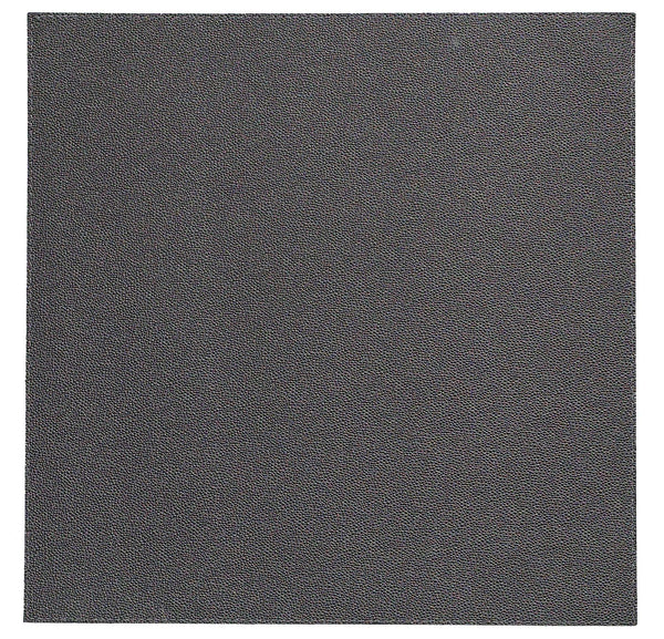 A close-up of the Bodrum Skate Placemat Round Charcoal Set of 4 shows a dark gray, textured surface reminiscent of fine-grain sandpaper or leather, filling the entire frame and reflecting its high-quality vinyl design.