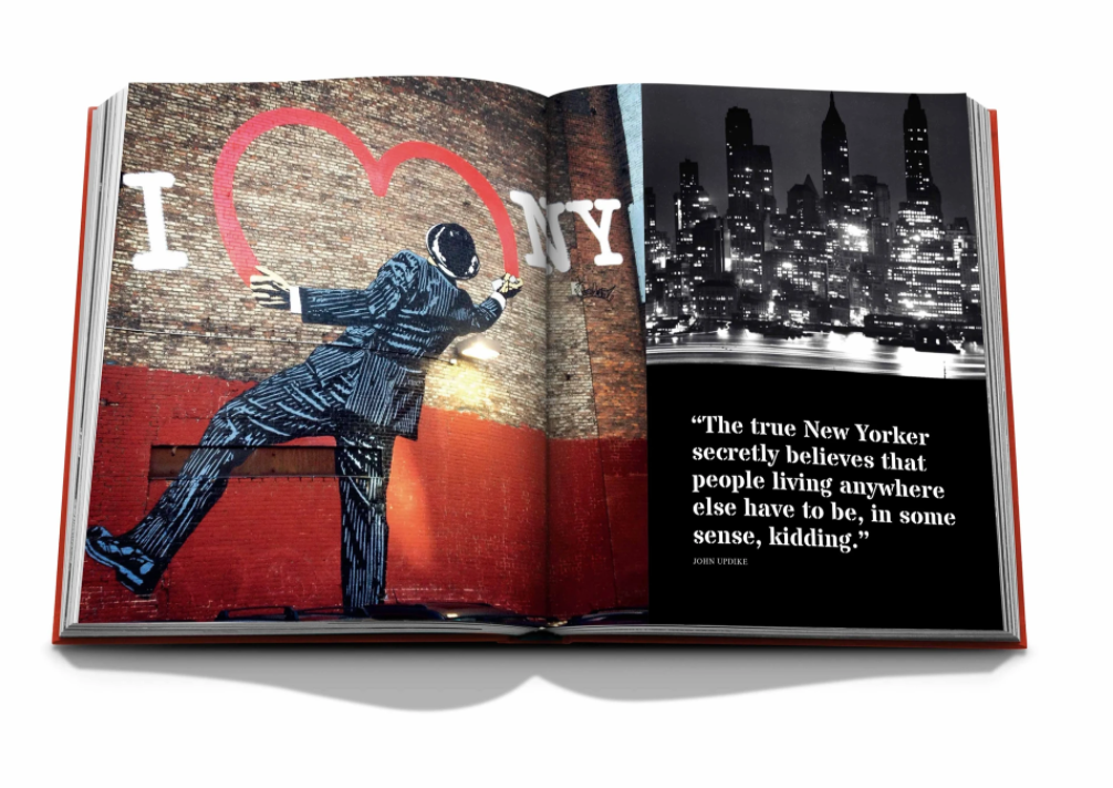 Assouline’s "New York By New York" book showcases iconic images—a man in a suit before an I ❤️ NY mural and a black-and-white city skyline with a quote—beautifully presented in a luxury slipcase.
