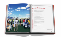 New York By New York by Assouline showcases iconic photos of people socializing outdoors with a city skyline on the left page and a "new york moments" list in red on the right, all elegantly housed in a luxury slipcase.