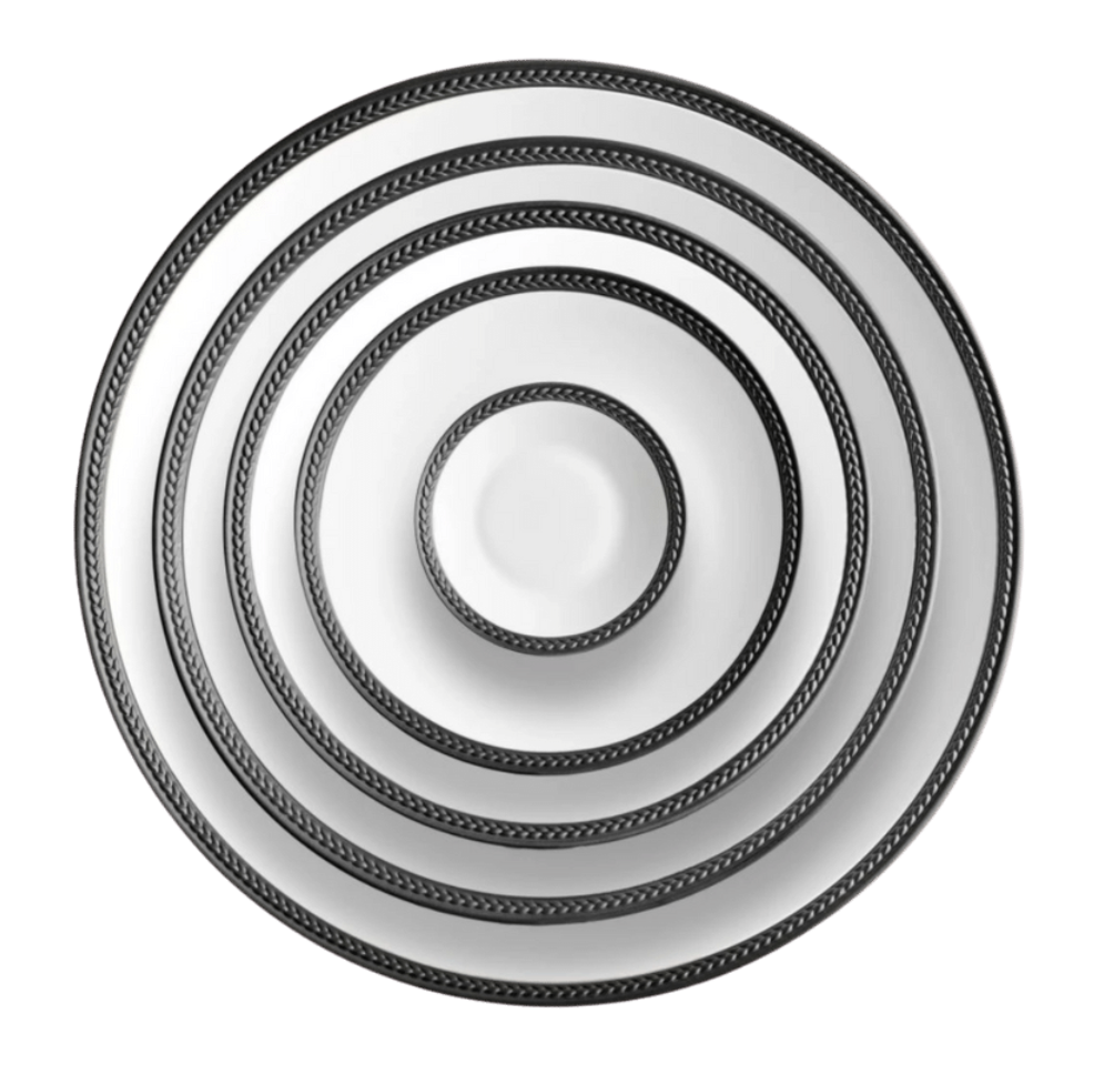 Five Soie Tressée Black dinnerware plates by L'Objet, made of white Limoges porcelain with black patterned rims, are stacked concentrically from largest to smallest and viewed from above against a white background.