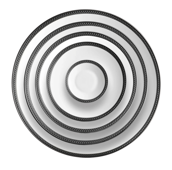 Five Soie Tressée Black dinnerware plates by L'Objet, made of white Limoges porcelain with black patterned rims, are stacked concentrically from largest to smallest and viewed from above against a white background.
