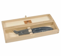 The "ULTIMATE" Berlingot Cheese Set Grey by Claude Dozorme features a wooden box with a hinged lid, revealing two high carbon stainless steel cheese knives with black handles securely placed inside.