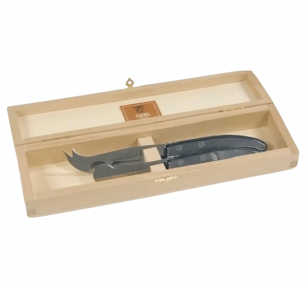 The "ULTIMATE" Berlingot Cheese Set Grey by Claude Dozorme features a wooden box with a hinged lid, revealing two high carbon stainless steel cheese knives with black handles securely placed inside.