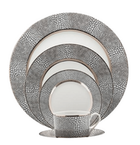 The Makassar Gray & Platinum Dinnerware by Royal Limoges/Bia Cordon Bleu includes five stacked plates and a cup with matching saucer, all handmade in France with a gray and white pebble pattern and silver edges in fine Limoges porcelain.