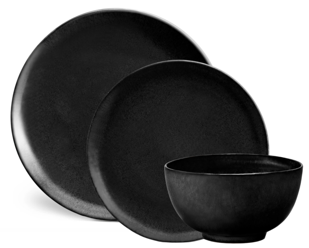 Three matte black stoneware pieces from L’Objet’s Terra Iron Dinnerware—two round handcrafted plates and a matching bowl—feature a smooth, minimalist design, beautifully arranged on a white background.