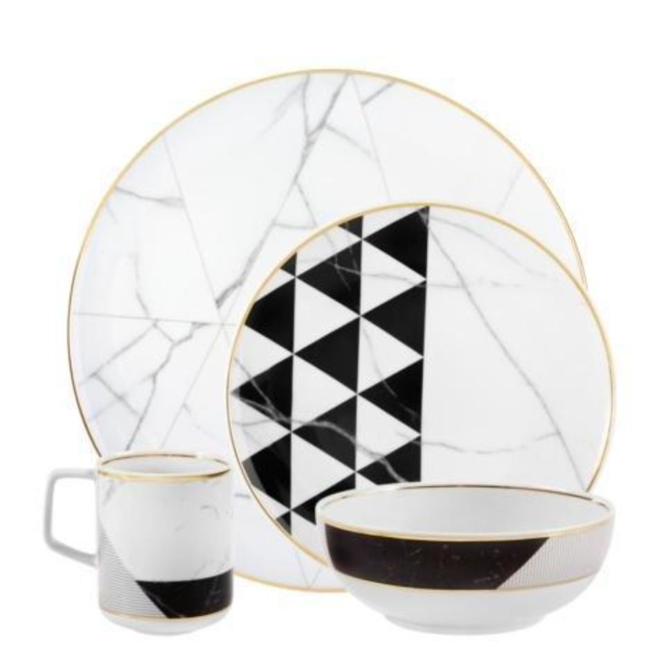 Vista Alegre’s Carrara by Coline Le Corréa Dinnerware set features a large plate, small plate, mug, and bowl in porcelain with gold rims, Carrara marble pattern, and bold black geometric triangles.