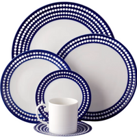 The Perlèe Blue Dinnerware by L'Objet features Limoges porcelain plates, bowl, cup, and saucer with a circular dot pattern on white and dark blue edges from the L’Objet Perlèe Collection.