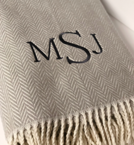The A Soft Idea Personalized Throw Blanket features a beige herringbone pattern, cream fringe, and MSJ monogrammed in large black letters for a classic, custom touch.