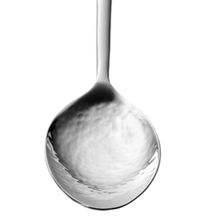 A close-up of the Mary Jurek Versa Vegetable Spoon facing up, showcasing its shiny, textured, reflective bowl and smooth handle extending upward.