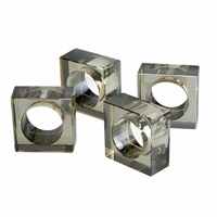 The Tizo Crystal Cube Napkin Ring Smoke Set of 4 features square-shaped, transparent napkin rings with circular openings, arranged on a plain white background.