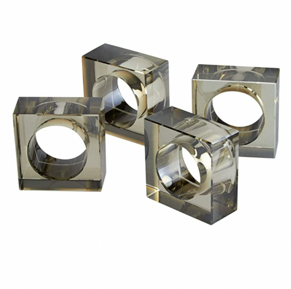 The Tizo Crystal Cube Napkin Ring Smoke Set of 4 features square, transparent rings with circular cutouts—perfect for adding a modern touch to stylish table settings.
