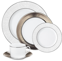Bernardaud’s Dune Dinnerware set includes a dinner plate, salad plate, bread plate, and teacup with saucer—each crafted in white Limoges porcelain with textured or metallic silver rims.