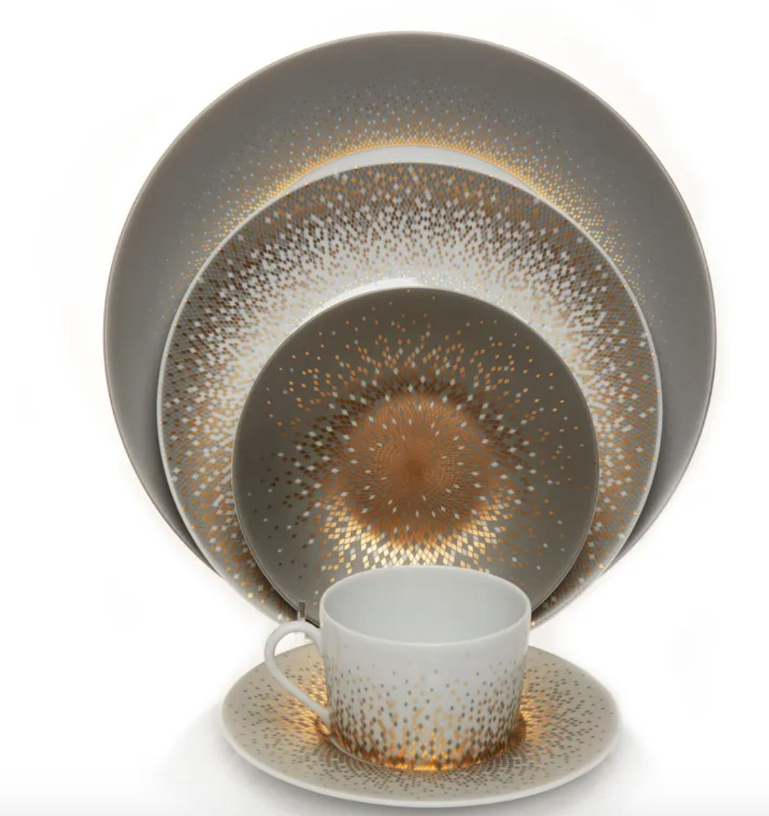 The Souffle D'or Dinnerware by Haviland includes plates and a teacup with saucer in Limoges porcelain, featuring a white base and gold dotted starburst patterns for an elegant, festive look.