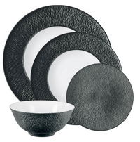 The Raynaud Mineral Irise Dinnerware - Black set includes two large plates, one small plate, and a bowl, all featuring a black textured exterior and smooth white interior for a stylish modern look.