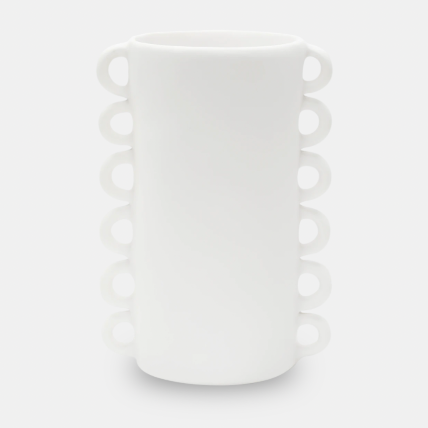 The Loopy Resin Vase White by Tina Frey is a tall, cylindrical handmade vase with two vertical rows of small circular handles on opposite sides. Displayed against a plain light gray background.