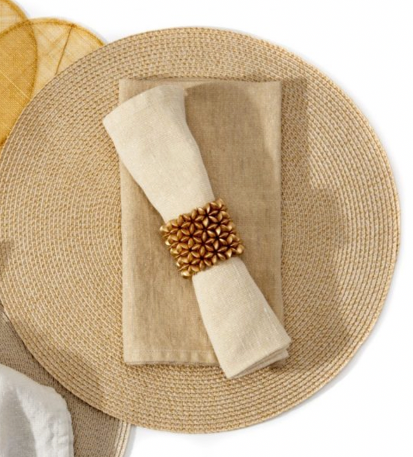 The Deborah Rhodes Metallic Casual Napkin Taupe & Gold Set of 4 is styled with a gold floral beaded ring on a round rattan placemat, with a mustard yellow placemat nearby—ideal for sophisticated holiday table decor.