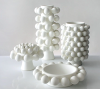 The KleinReid Nimbus Dome Vase Onyx features a glossy white surface with raised, rounded bubble patterns, showcasing the brand's signature handmade porcelain craftsmanship against a neutral background.