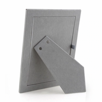 The Enamel Thin Frame - Denim by Addison Ross is displayed from the back with a two-way easel stand for upright placement, empty and set against a white background. Silver trim accents highlight its stylish gray design.