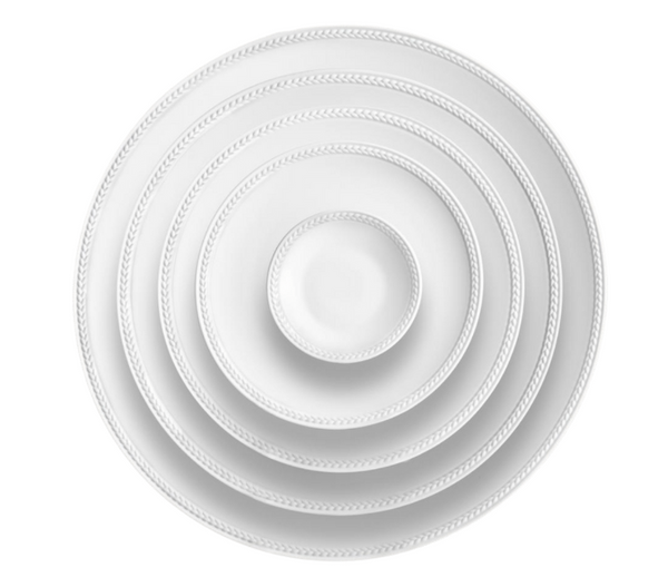 Five Soie Tressée White Dinnerware plates by L'Objet are stacked concentrically, viewed from above. Each Limoges porcelain plate features a subtle braided border, set against a plain white background.