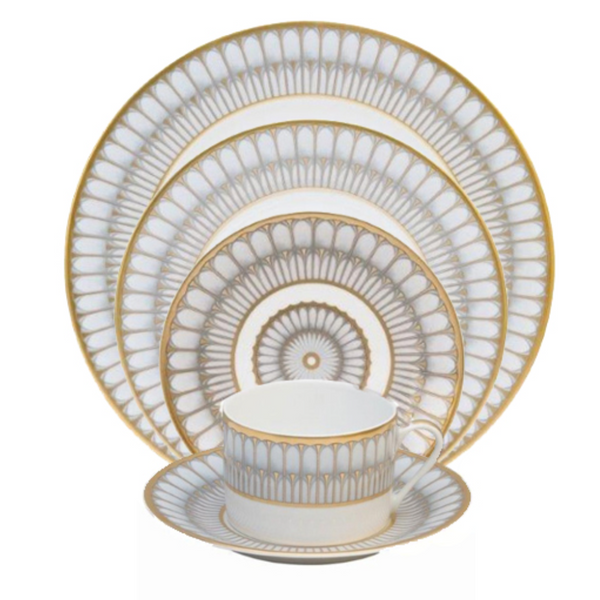 The Philippe Deshoulieres Arcades Gold Dinnerware set includes fine china dinner, salad, dessert, and bread plates plus a teacup and saucer, all adorned with intricate gold and gray geometric patterns.