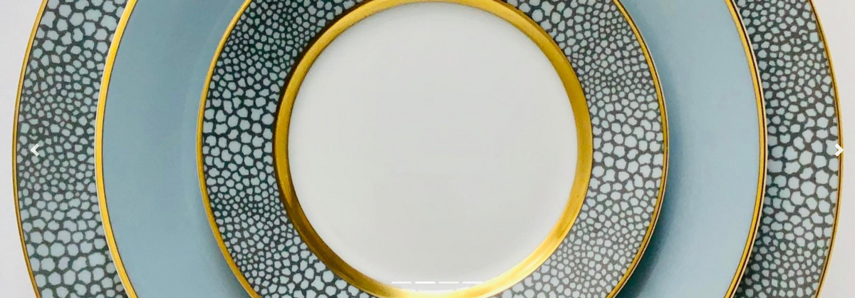 Three stacked Makassar Gold Dinnerware plates by Royal Limoges, handmade in France, feature a blue and white pattern with gold filet and textured, scale-like rims.